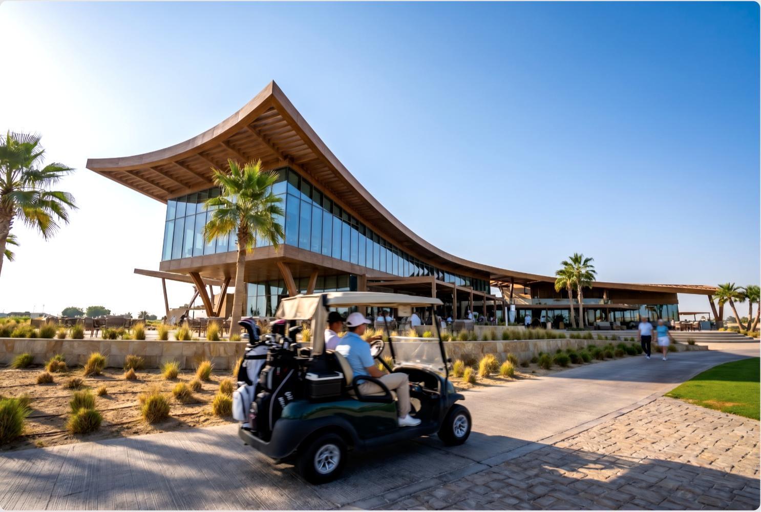 The Greens — golf cart carrying golfers along the path with the curved clubhouse behind
