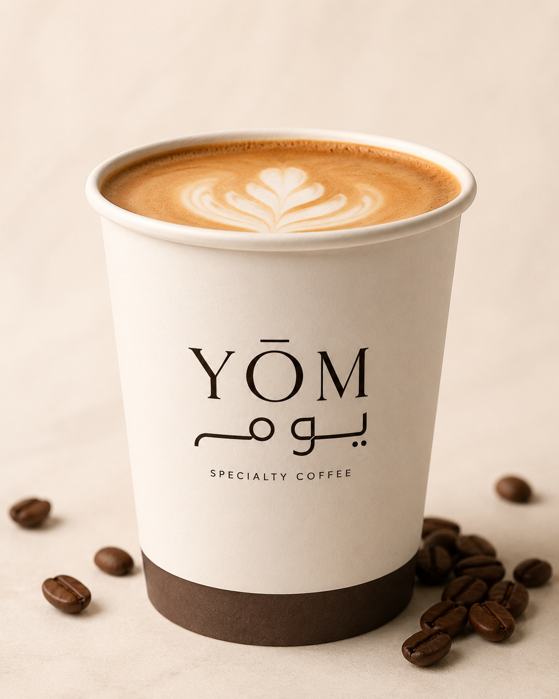 YOM Specialty Coffee — branded takeaway cup with the YOM wordmark and coffee beans