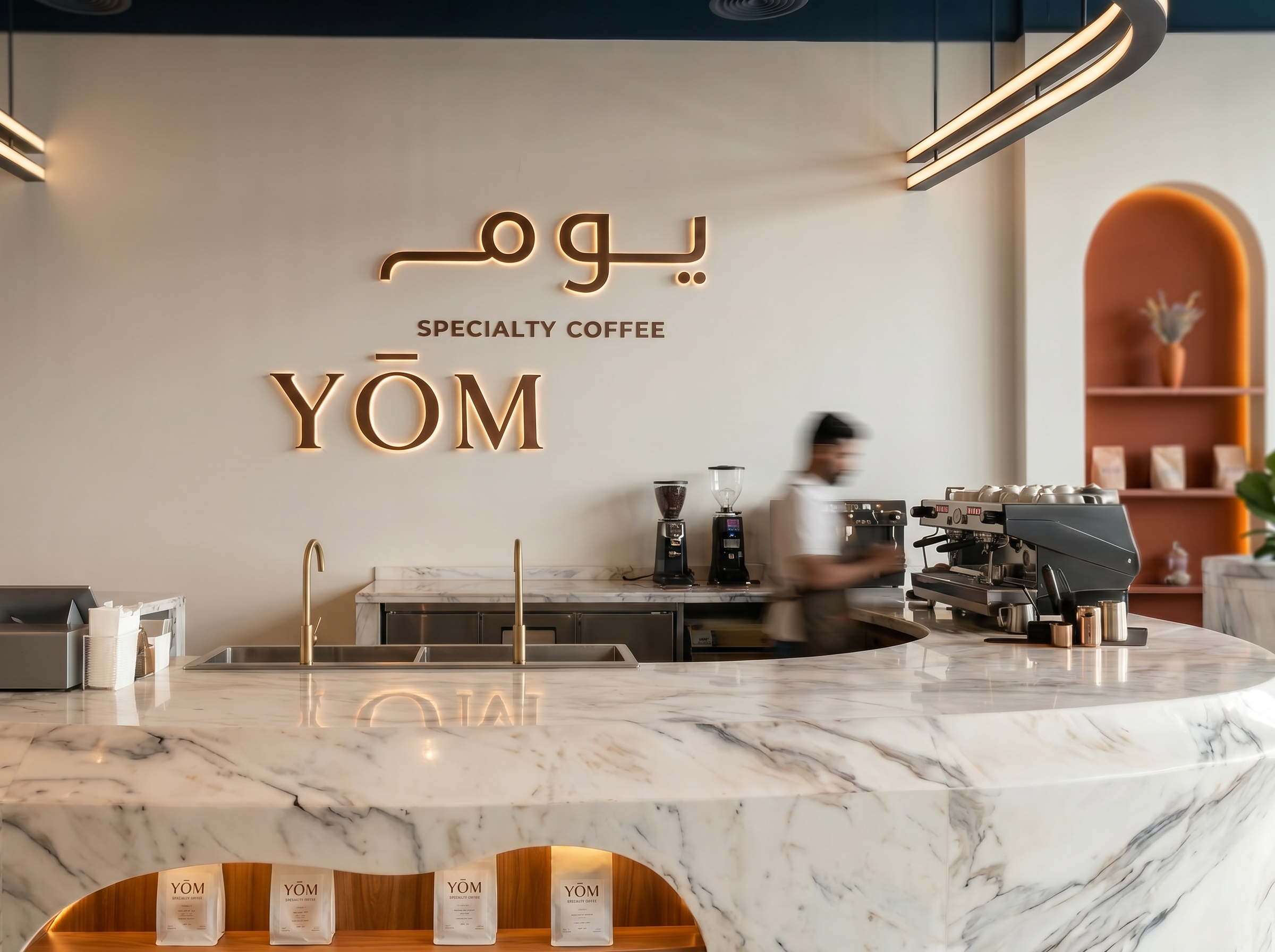 YOM — barista counter with the YOM signage backdrop, marble counter and brass details